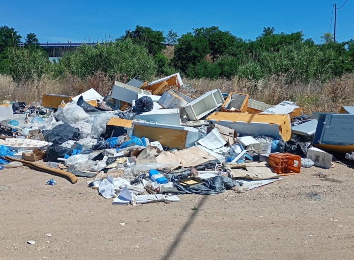 Rifiuti abbandonati in una discarica abusiva a Lesina, vicino a un cartello di bonifica.