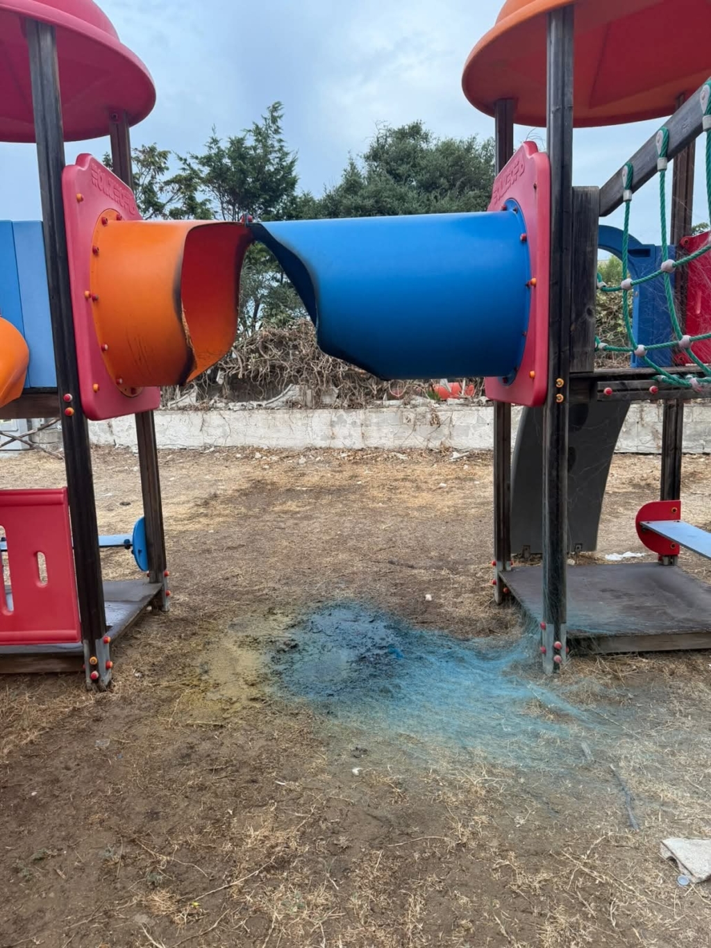 Scivolo per bambini danneggiato da incendio a Foce Varano, con plastica bruciata e annerita.