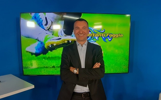 Stemma del Real Rodi su sfondo di un campo da calcio verde.