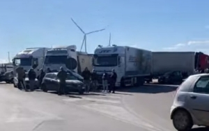 Trattori e camion in protesta bloccano un'autostrada italiana, simbolo della crisi economica del settore.