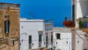 Mappa della Puglia con icone di case e turisti, simbolo della nuova regolamentazione sugli affitti brevi.