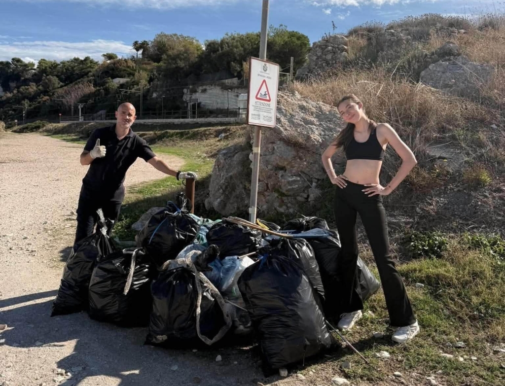 Famiglia belga con bambini mentre pulisce una spiaggia di Rodi Garganico.