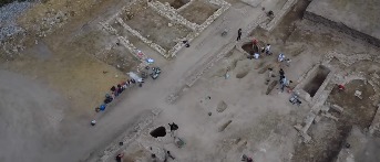 Archeologi esaminano resti di antiche mura di una chiesa durante scavi a Siponto.