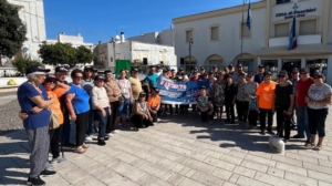 Anziani sorridenti praticano attività fisica all'aperto durante l'evento 'Movimenti d'Argento' a Peschici.