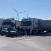 Trattori e camion in protesta bloccano un'autostrada italiana, simbolo della crisi economica del settore.